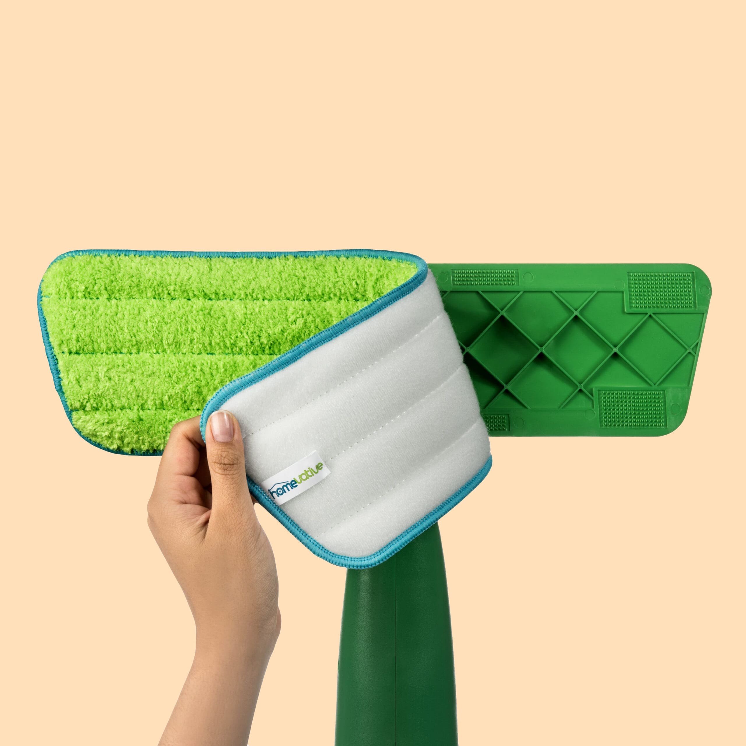 A photo of a hand model removing a cleaning pad from a mop head.