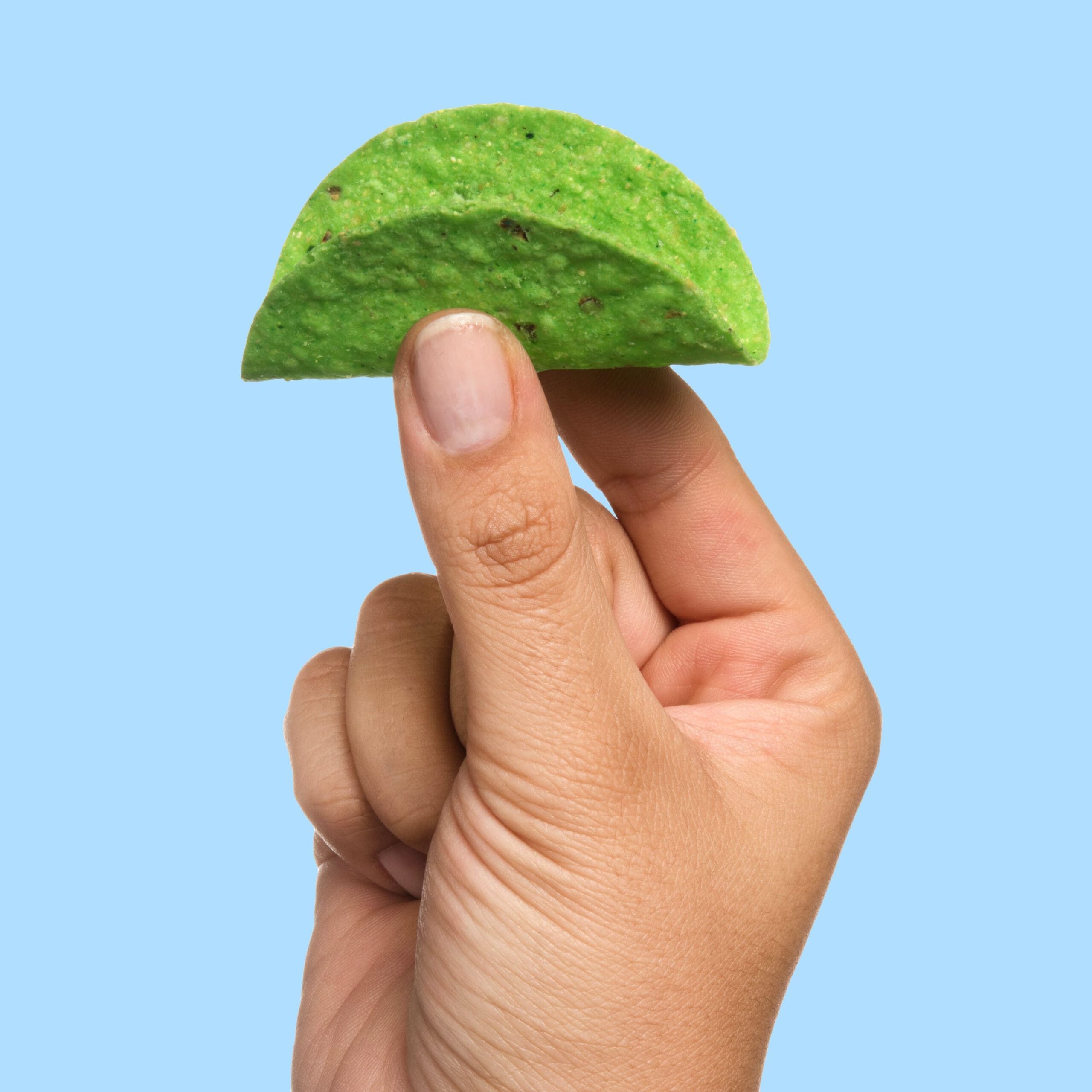 A hand model holding a tiny taco shell between two fingers