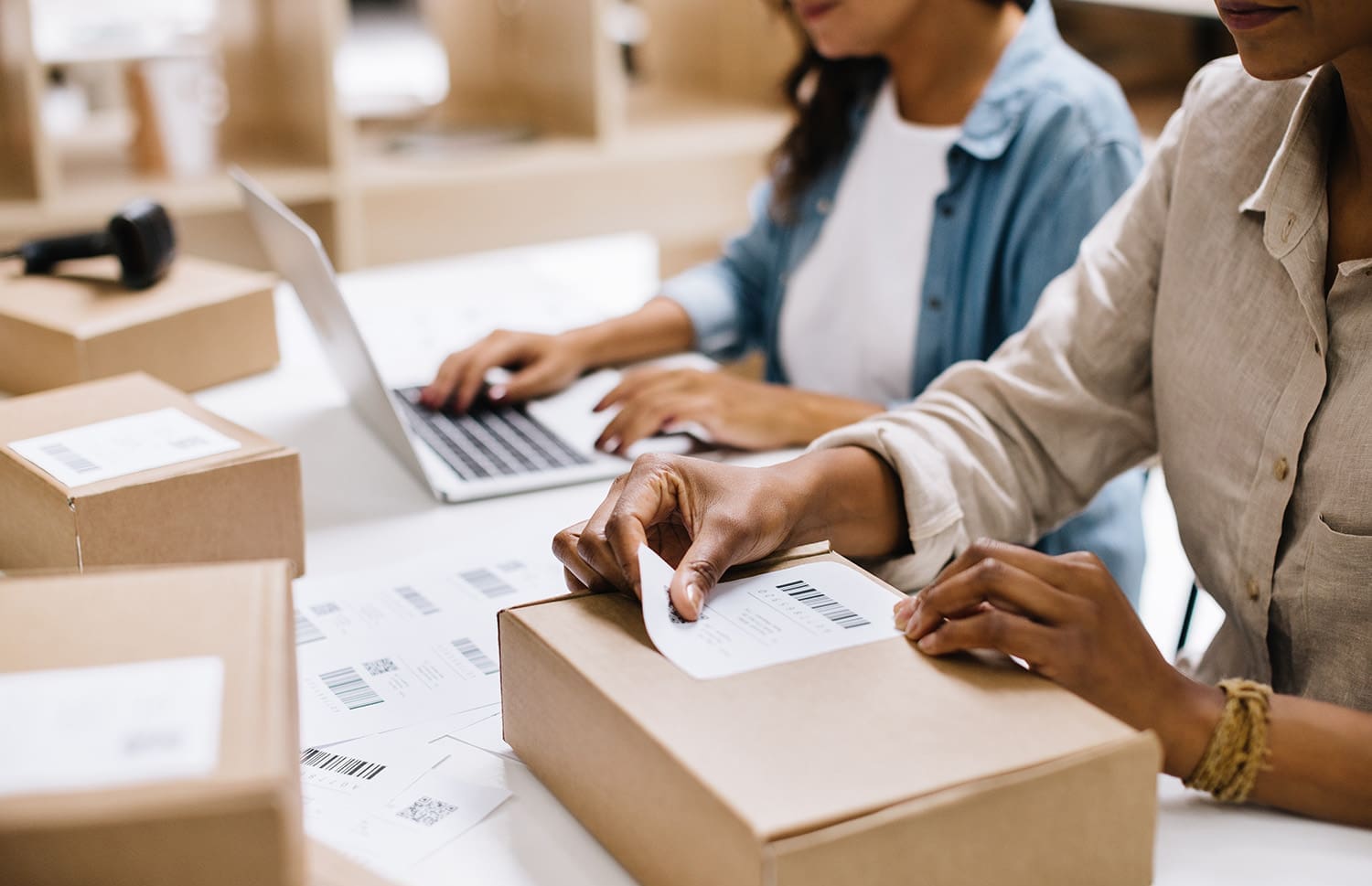 Photo of a woman placing a shipping label on a box.